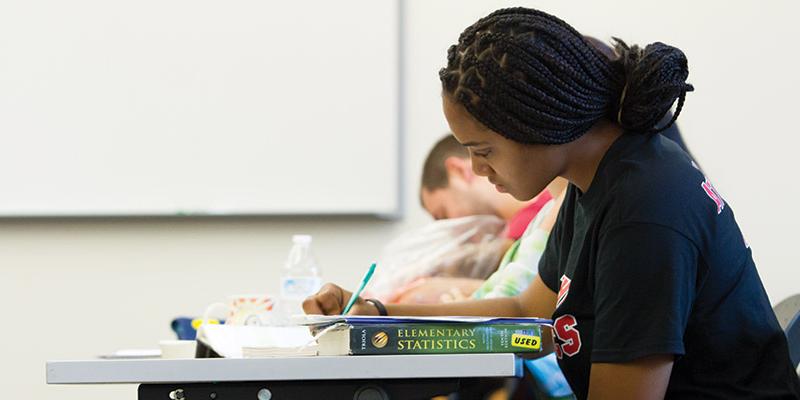 Student writing in the classroom at Bryn Athyn College