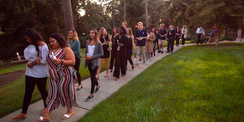 Students together during candlelight walk event at orientation