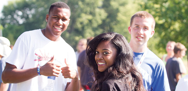 Students smiling outside on the Brickman patio