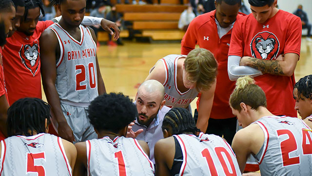 Men's baskeball coach speaks to the athletes during a timeout