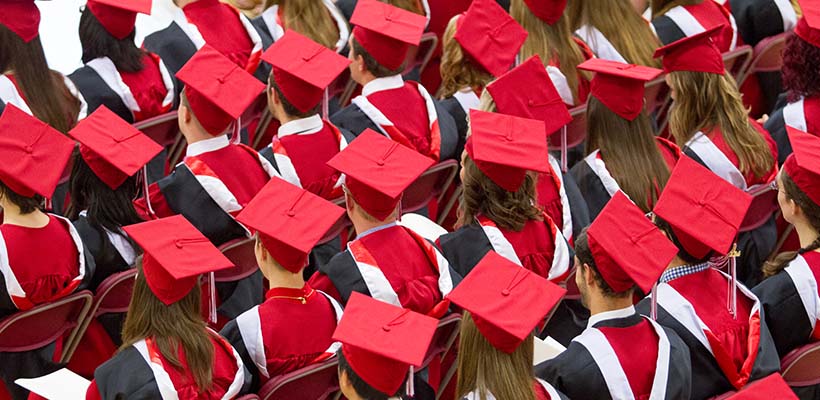 Sea of students wearing traditional red caps and gowns during their graduation ceremony