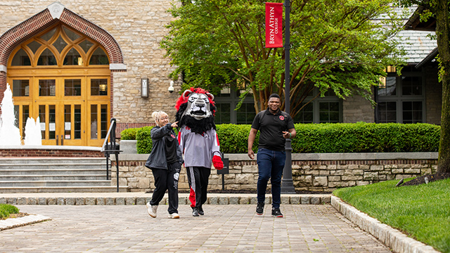 Mascot Leo the Lion tours campus with two students