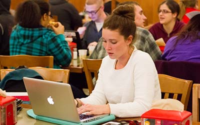 Bryn Athyn College student writing on a laptop