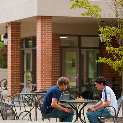 Students play chess outside on the Childs Hall patio at Bryn Athyn College