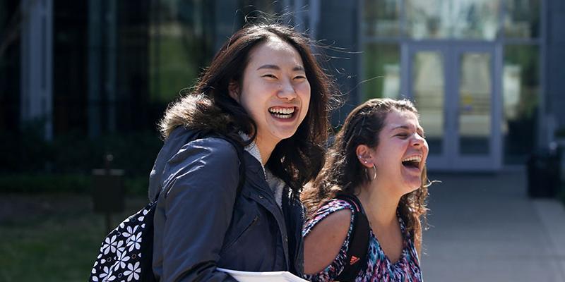 Bryn Athyn College students laughing and smiling as they walk to class
