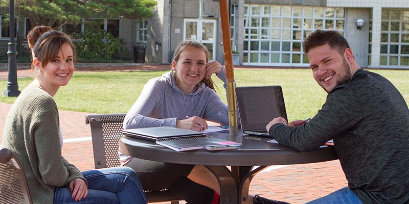 Students working on a project on the Brickman patio at Bryn Athyn College