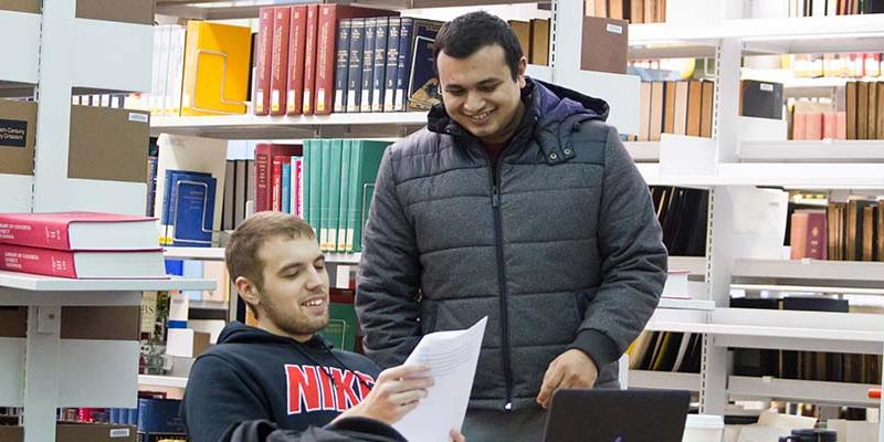 Bryn Athyn College students reviewing papers in the library