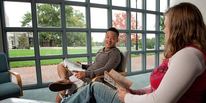 Bryn Athyn College students sitting in front of the window wall at the Swedenborg Library
