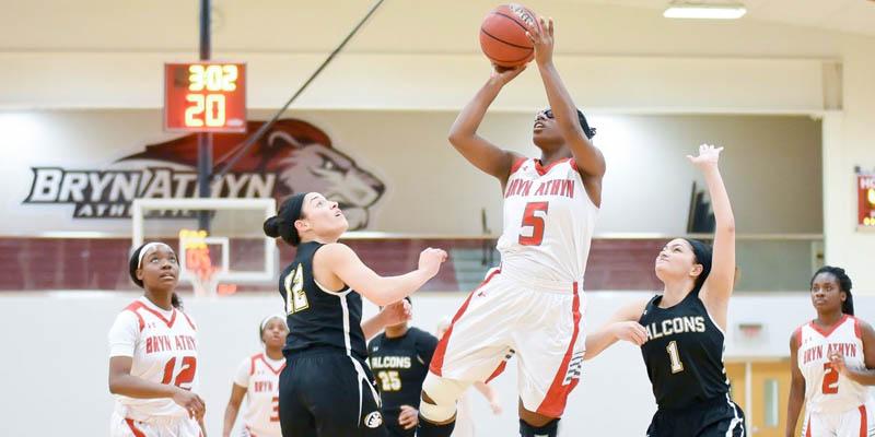 Basketball team athlete leaps as to make a shot